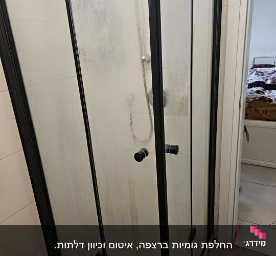 מקלחון זכוכית עם דלתות שקופות ומוט מקלחת